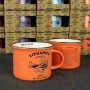 Mažas oranžinis puodelis Lituanica su trumpai aprašyta skrydžio istorija